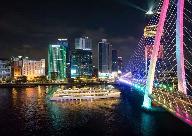 A city skyline at night with illuminated buildings and a bridge with colorful lights. 4