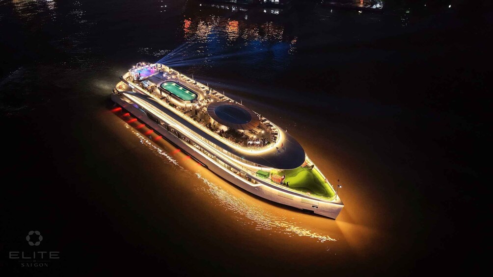 A large cruise ship with a swimming pool and a covered deck area, illuminated at night. 5