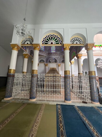 An ornate interior with columns, arches, and a decorative gate. 4