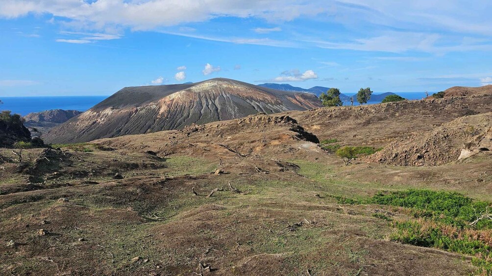 A rugged landscape with a prominent hill and sparse vegetation. 2