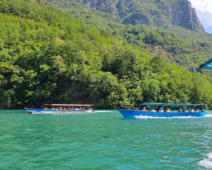 Two boats on turquoise water surrounded by lush green hills. 4