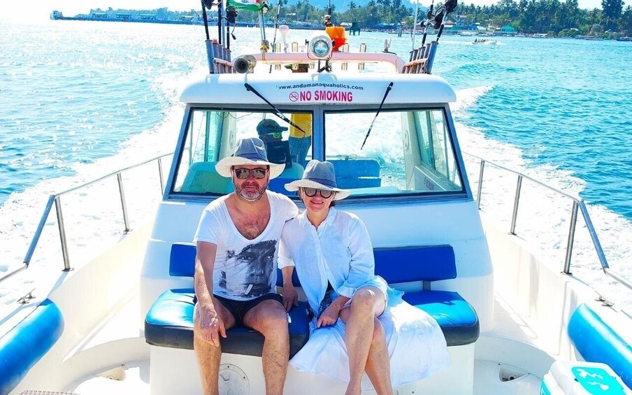Two people sitting on a boat with a 'NO SMOKING' sign. 2