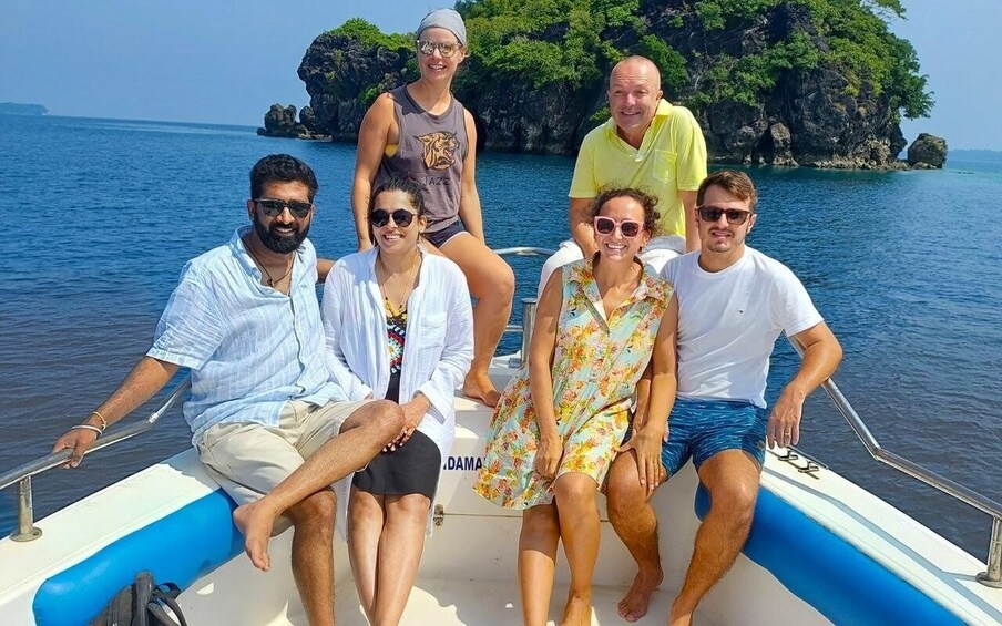 A group of people on a boat with a rocky island in the background. 5