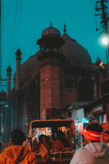 A mosque with a large dome and minarets, surrounded by a busy street with people and shops. 2