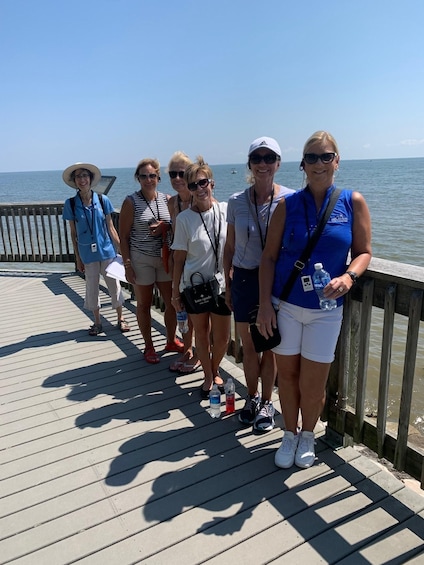 A group of people on a wooden pier by the sea. 5