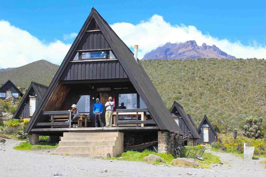 A triangular wooden structure with a staircase leading up to a platform. 1