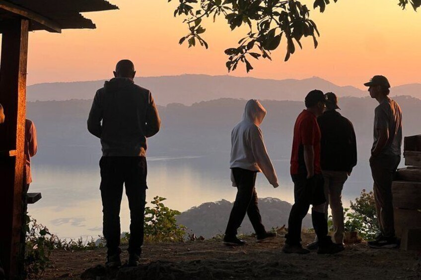 Un grupo de personas junto a un lago al atardecer. 3