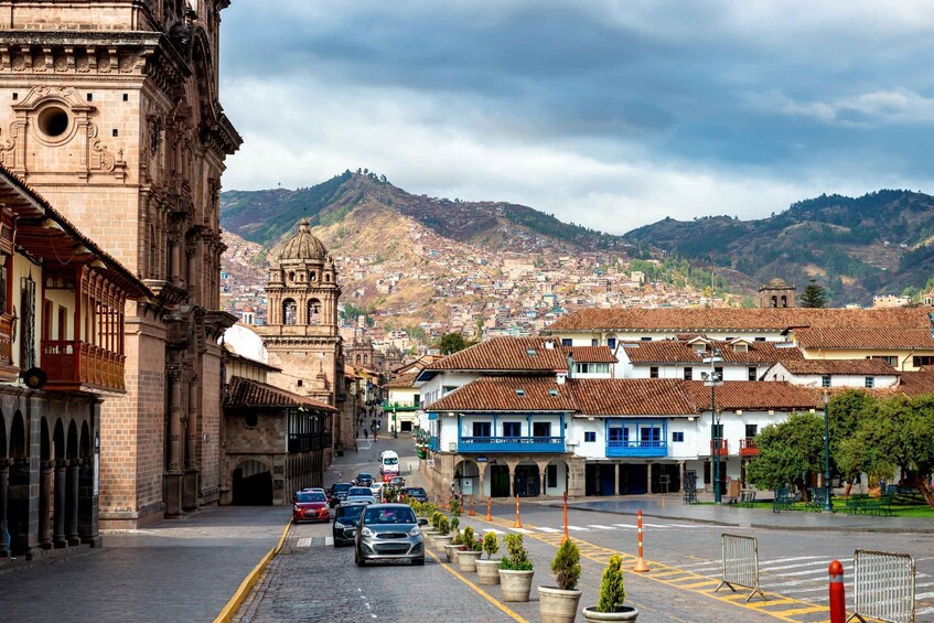 A historic street with buildings, a church, and a mountain in the background. 5