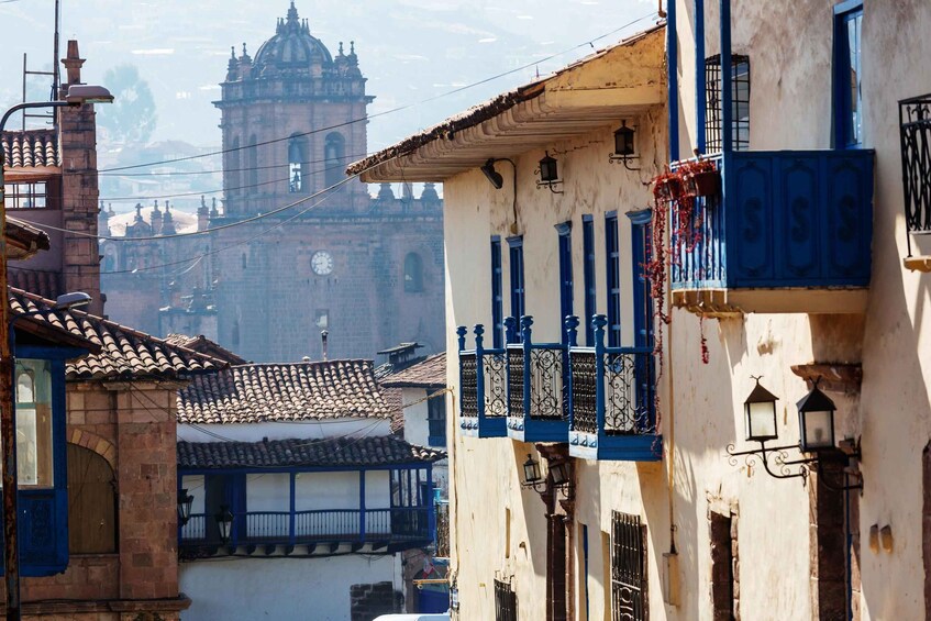A street with buildings, a clock tower, and a church in the background. 2
