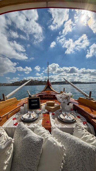 A boat deck with a table set for a meal, a sign reading 'TOCETHER FOREVER,' and a backdrop of a coastal cityscape under a partly cloudy sky. 4