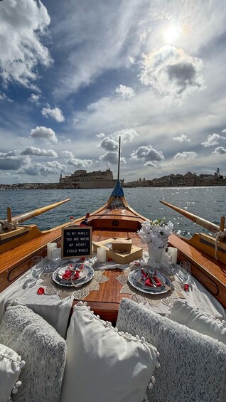 A boat with a table set for a meal, a sign reading 'To my family, you are where my heart feels whole,' and a cityscape in the background. 3