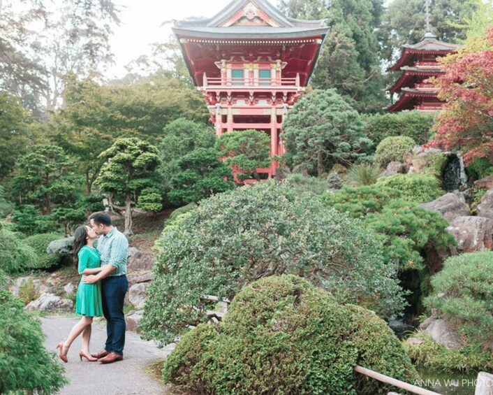 A couple embracing in a lush garden with traditional Japanese architecture. 2