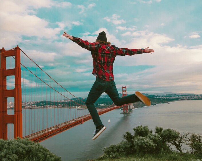 A person jumping in front of the Golden Gate Bridge. 1