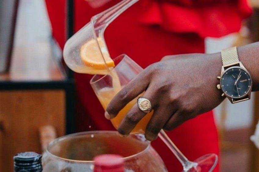 A person pouring a drink from a shaker into a glass. 4