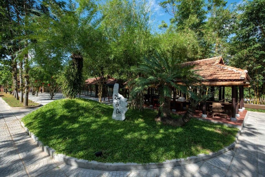 A park with a gazebo, a stone monument, and lush greenery. 5