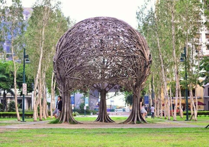 A spherical sculpture with tree-like structures in a park. 4