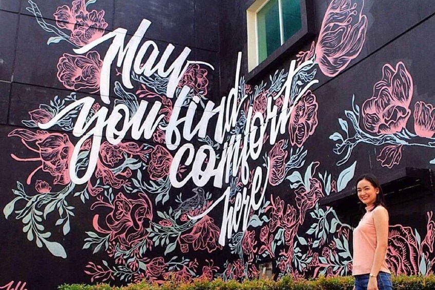 A mural with floral designs and the phrase "May you find your home here" on a building. 3