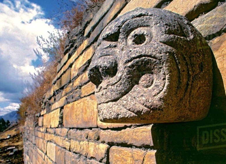 A stone wall with a carved head sculpture. 2
