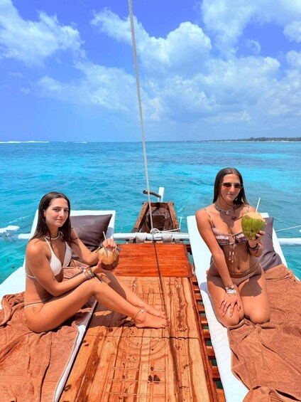 Two people on a boat with a wooden deck, tropical sea, and clear sky. 2