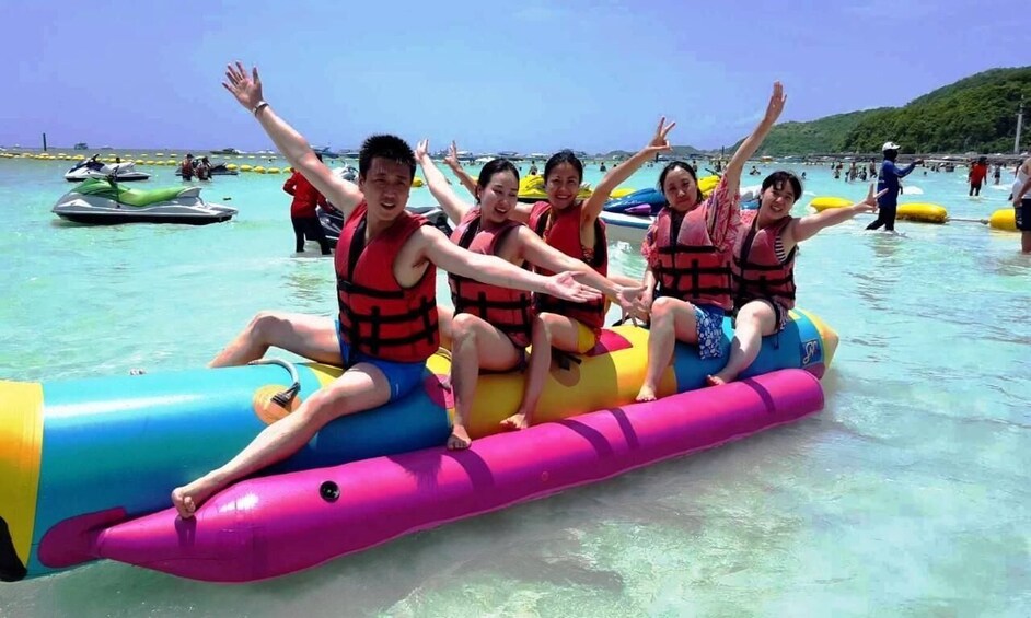 People on a colorful inflatable raft in clear water. 2