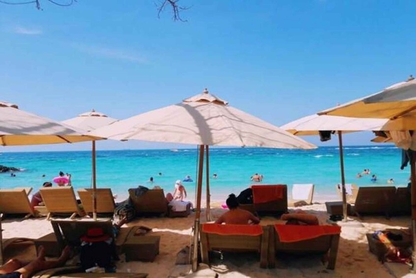 A beach with sun umbrellas and lounge chairs. 5