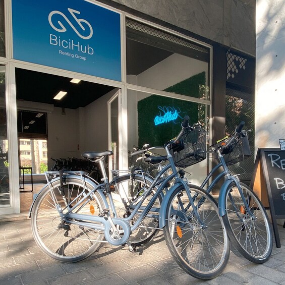 A BiciHub rental station with bicycles and a neon sign. 3