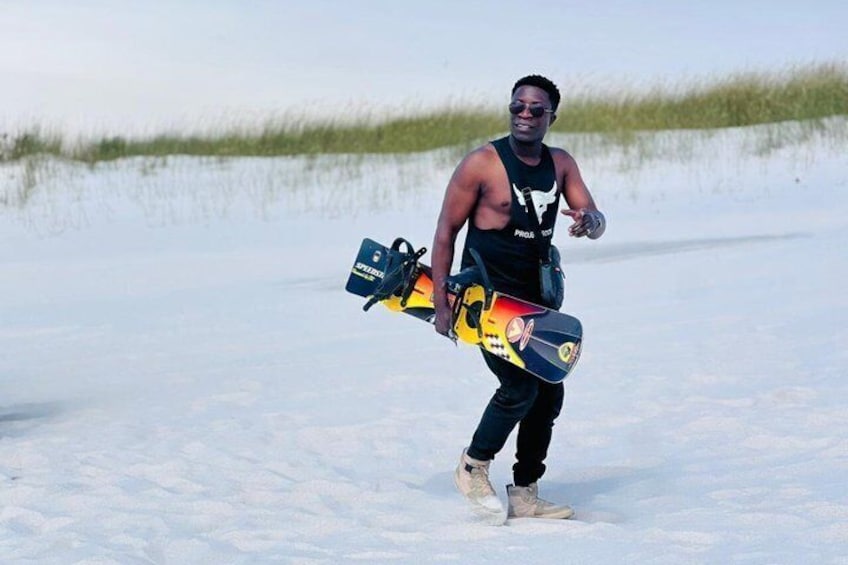 En person som bär på en kajak och en paddel på en snötäckt strand. 1