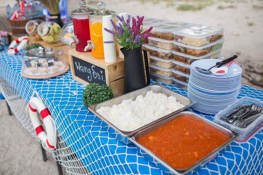 A buffet table with food items, including rice, a red sauce, and various dishes in containers. 5