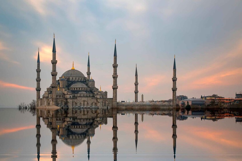 A mosque with multiple minarets and a dome, reflecting in a calm body of water. 1