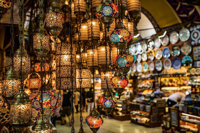 A market with hanging ornate lanterns and a variety of colorful plates. 4