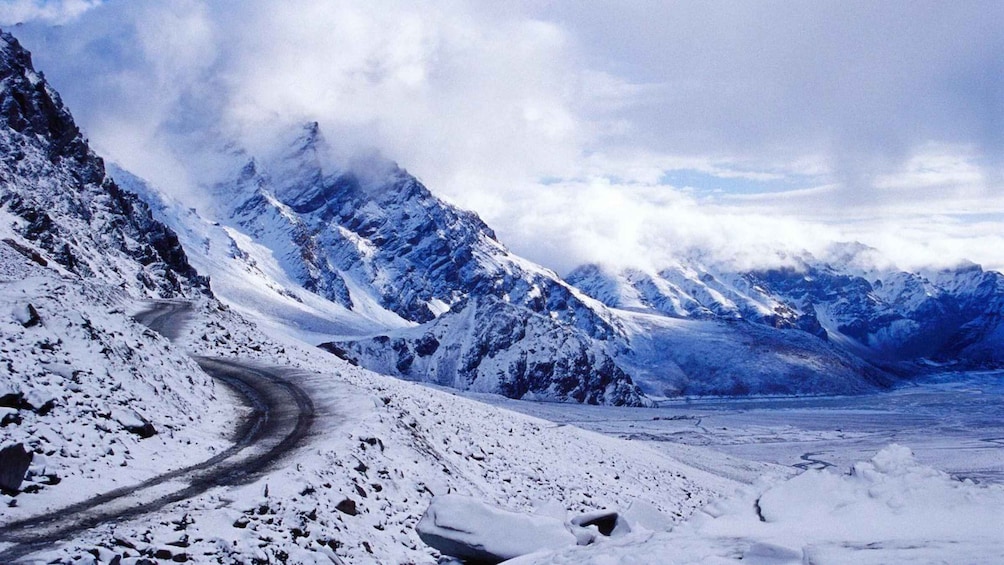 A snow-covered mountain road winding through a glacier valley. 2