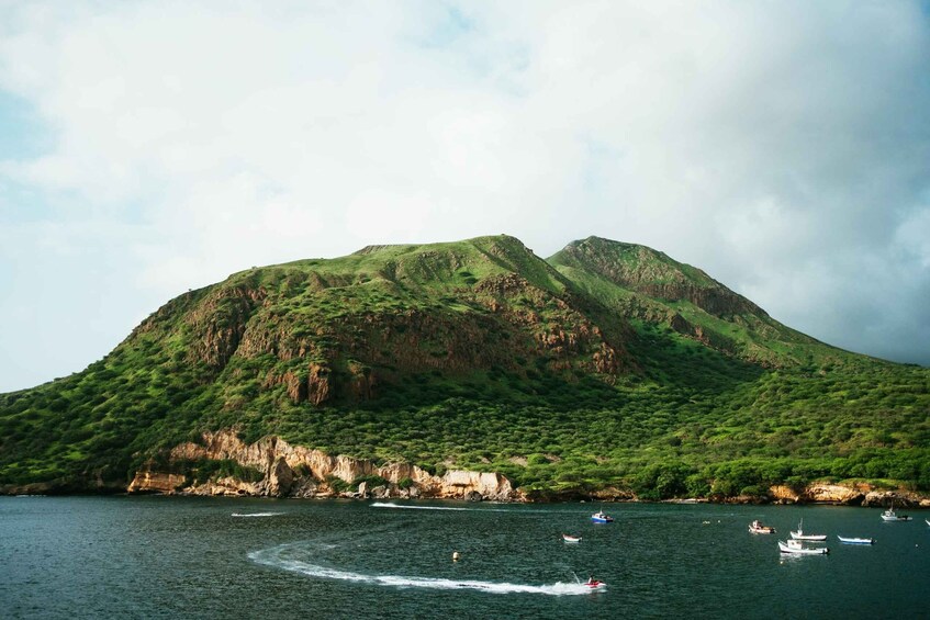A mountainous landscape with a body of water in the foreground. 2