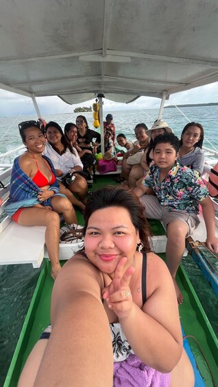 A group of people on a boat with a view of the sea and a distant island. 3