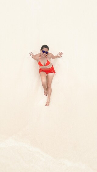 A person lying on a sandy beach. 5