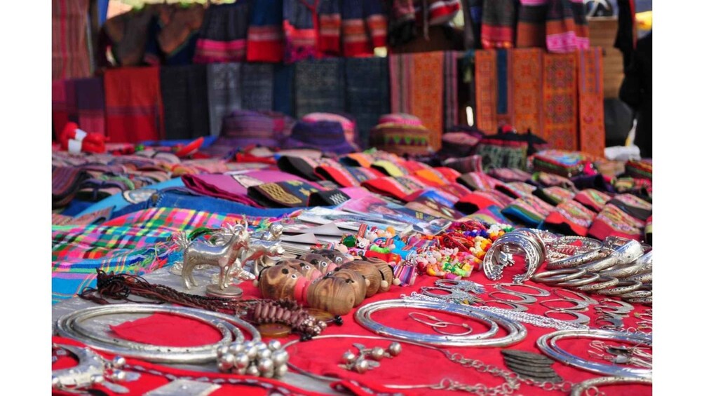 A market stall with colorful textiles, jewelry, and traditional items. 1