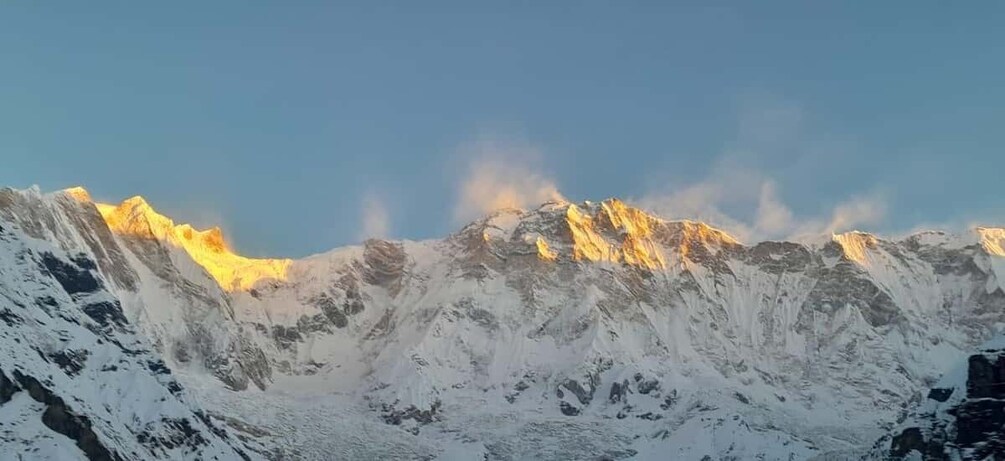 A snow-covered mountain range with sunlight illuminating the peaks. 4