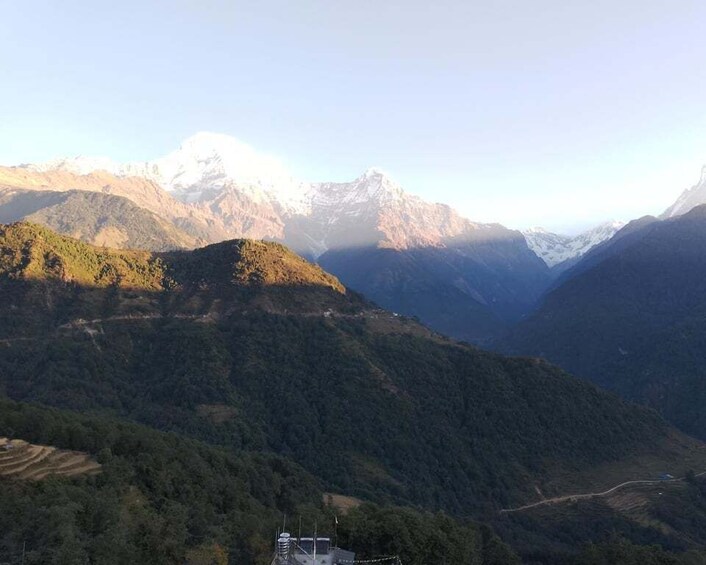 A mountainous landscape with snow-capped peaks and dense forested areas. 3