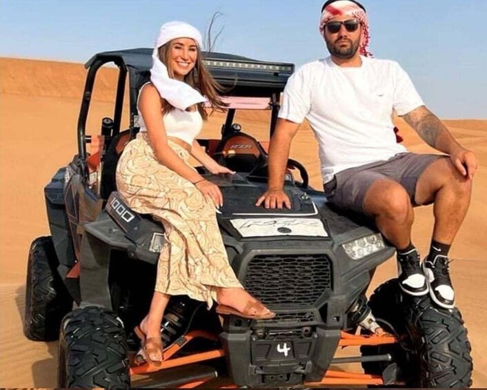 A couple on a dune buggy in a desert. 4