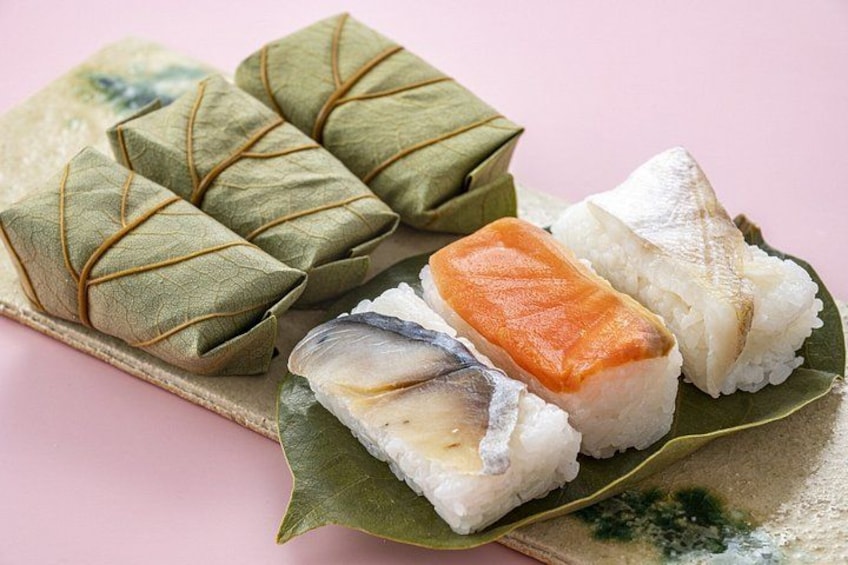A plate of food with wrapped items and rice. 4
