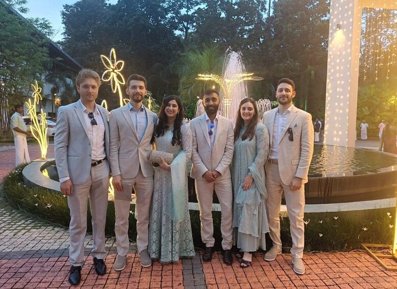 A group of people standing in front of a fountain with illuminated decorations. 4