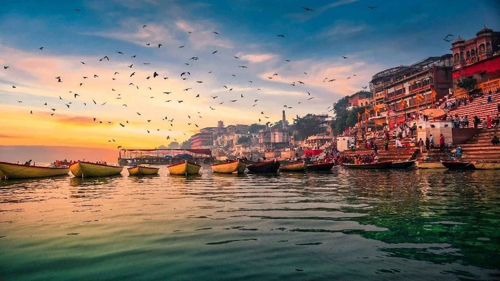 A riverside cityscape with boats and people. 1