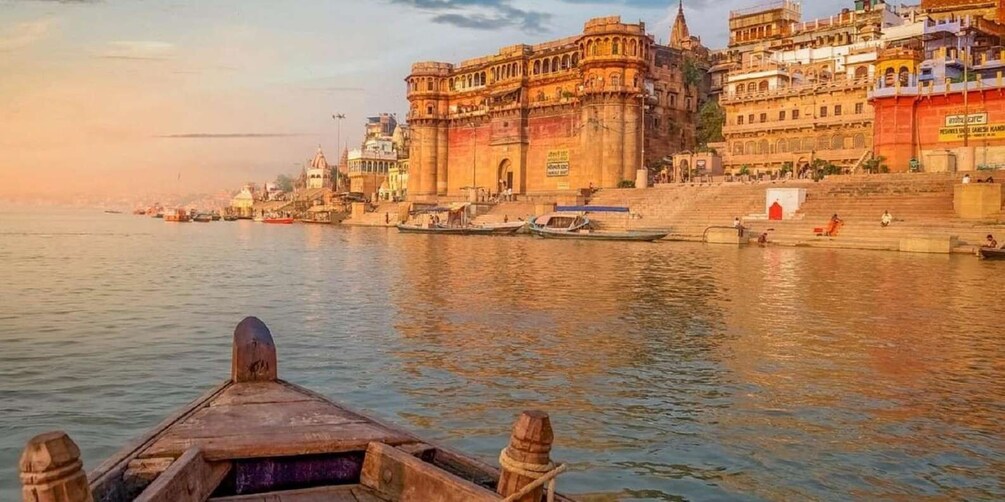 A river with boats and a large historic building on the riverbank. 2