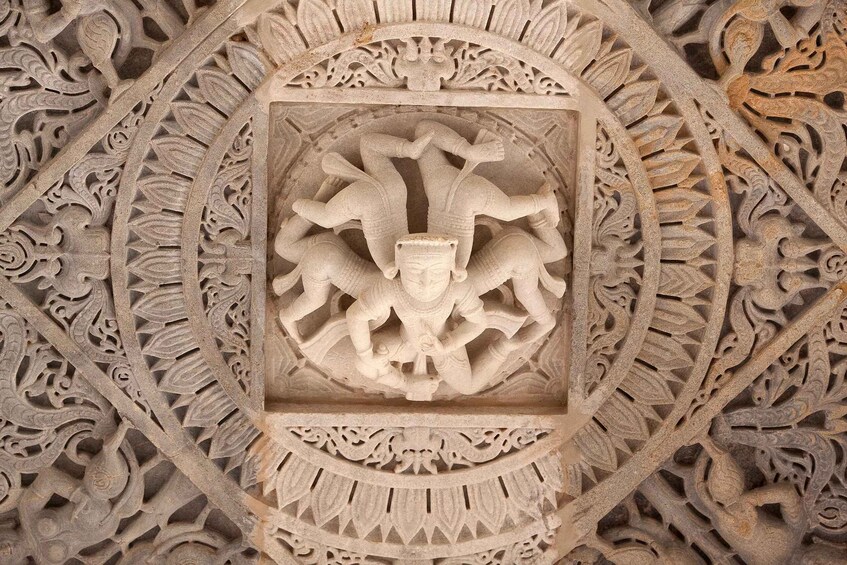 A detailed stone carving with a central figure surrounded by intricate patterns. 5