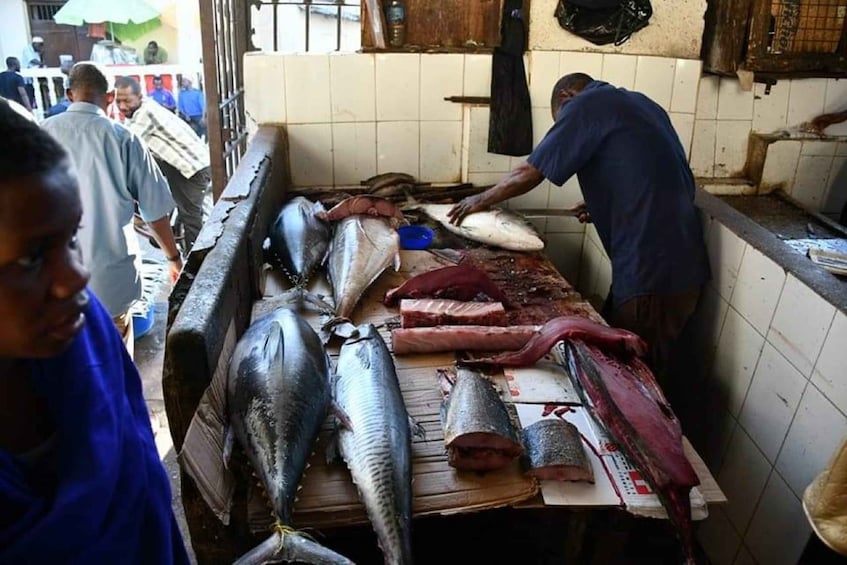 A market stall with various fish and meat products displayed on a table. 5