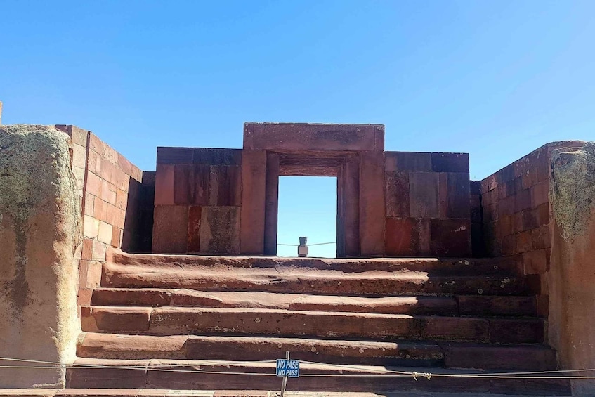 A set of stone steps leading to a doorway framed by large stone blocks. 4
