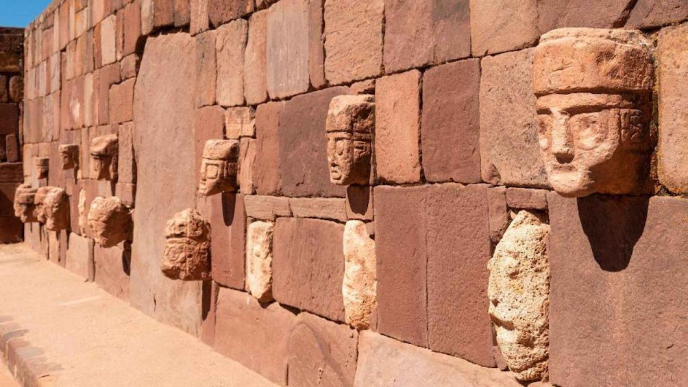 A row of ancient stone carvings on a wall. 3