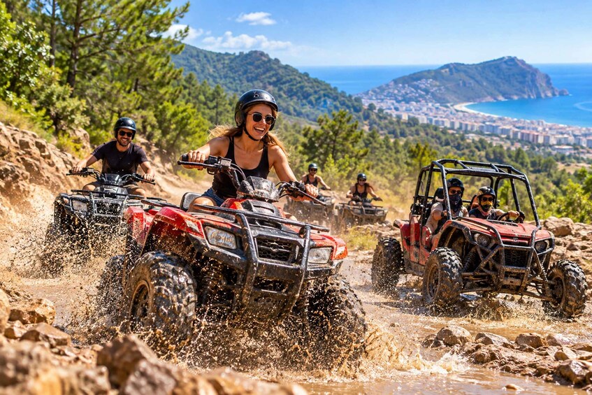 People riding ATVs on a rocky trail with a coastal city in the background. 1