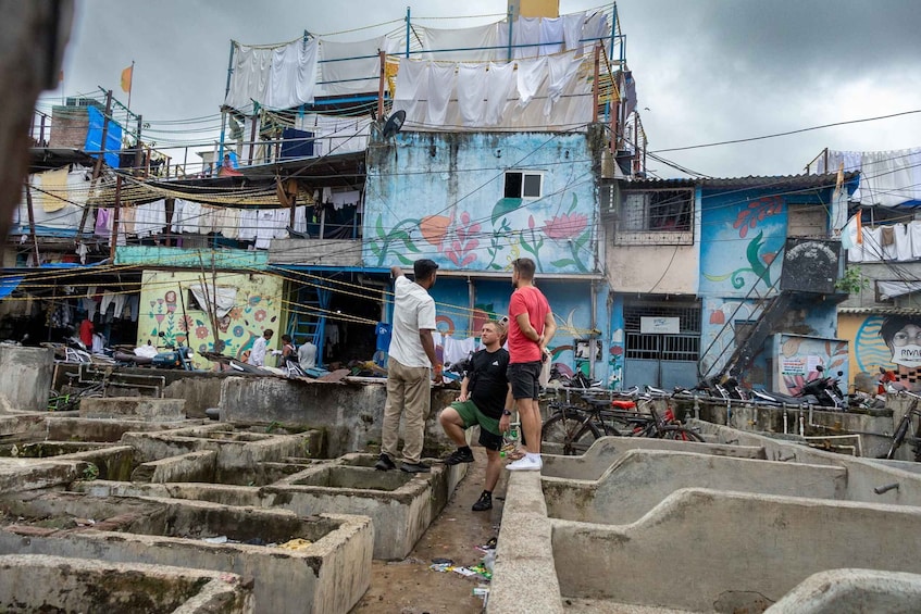 A densely populated urban area with multi-story buildings, some with colorful murals. 3