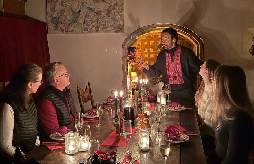 A dinner setting with a table set for four, candles, and a person standing in front of the table. 2