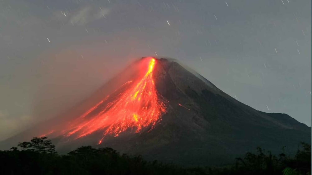 A volcano erupting with lava flowing down its side. 2